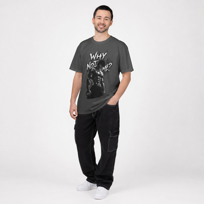 A man modeling a dark gray graphic t-shirt with the text 'WHY NOT ME?' and a black-and-white illustration, paired with black cargo pants and white sneakers, against a light gray studio background.