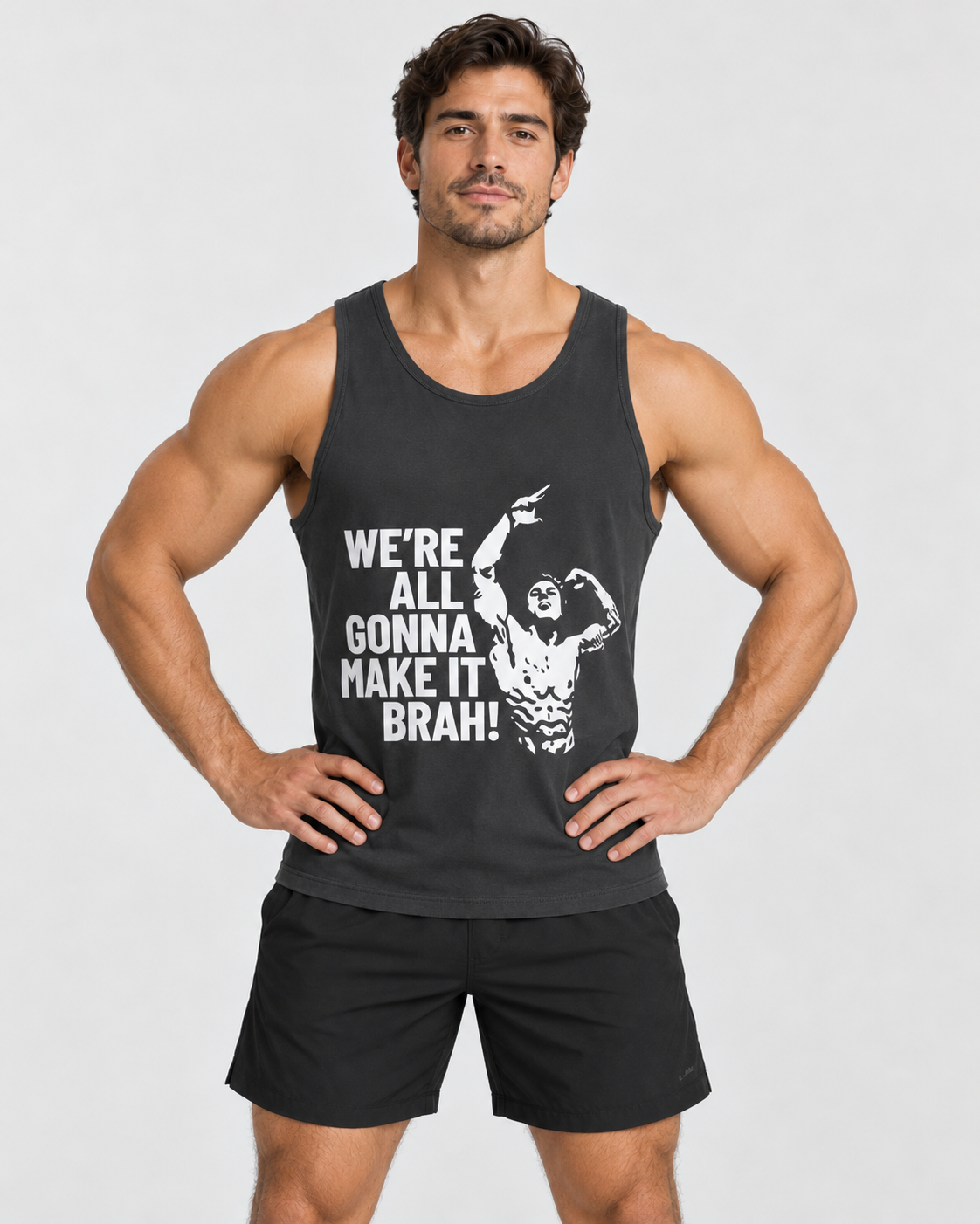 A muscular man modeling a dark gray tank top with a white graphic text that reads 'WE'RE ALL GONNA MAKE IT BRAH!' and an illustration of a bodybuilder, paired with black athletic shorts, against a light gray background.