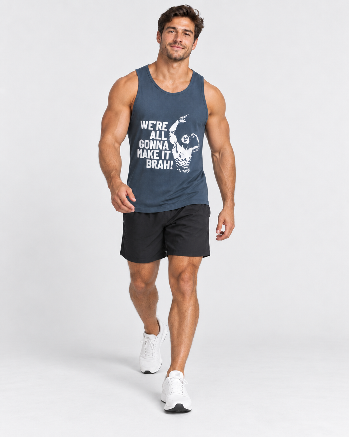 A muscular man wearing a navy blue tank top with a white graphic and text that reads 'WE'RE ALL GONNA MAKE IT BRAH!' paired with black athletic shorts and white sneakers, walking against a light gray studio background.