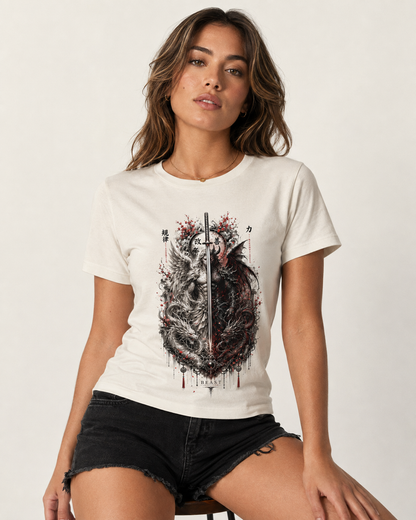 A woman wearing a white short-sleeve graphic t-shirt with a detailed black and red dragon design on the front, paired with black denim shorts, posed against a clean off-white studio background.