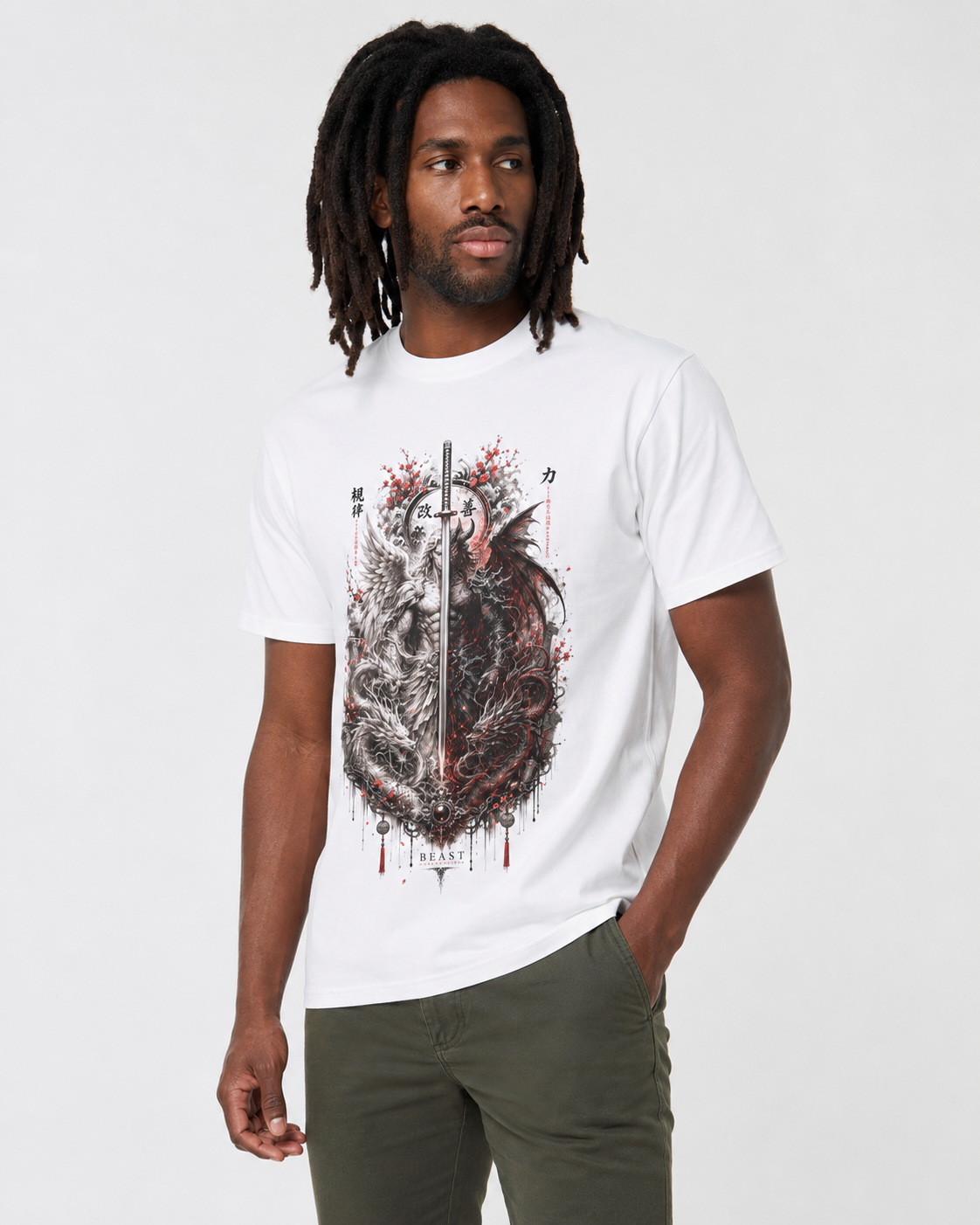A man wearing a white crewneck t-shirt with a detailed graphic print of a split heart, one side showing a winged dagger and the other a snake, with red blood splatters. He is also wearing olive green pants against a plain light gray background.