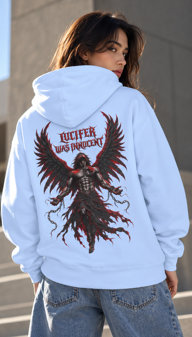 A woman shown from the back wearing a light blue hoodie with a large graphic print of a dark winged figure and the text 'LUCIFER WAS INNOCENT' on the back, paired with blue jeans.