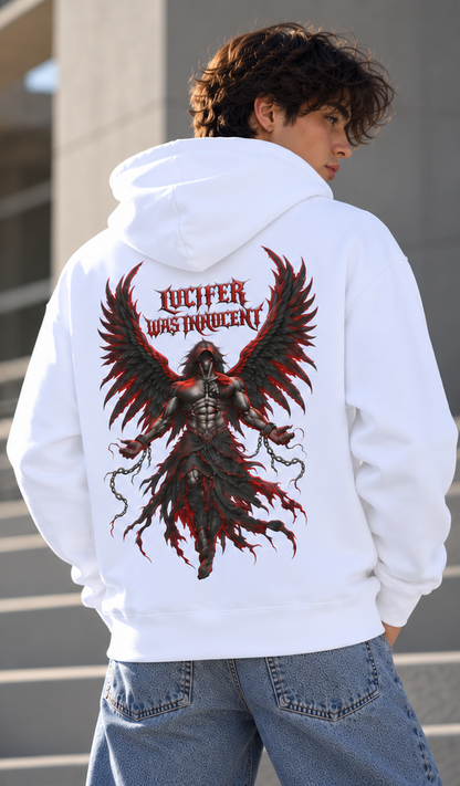 A man wearing a white hoodie with a large graphic print on the back, featuring a dark angelic figure with red and black wings and the text 'LUCIFER WAS INHOCENT'.