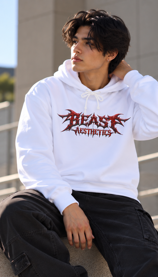 A man wearing a white hoodie with a red and black 'BEAST AESTHETICS' graphic, paired with black cargo pants, sitting outdoors on concrete steps.